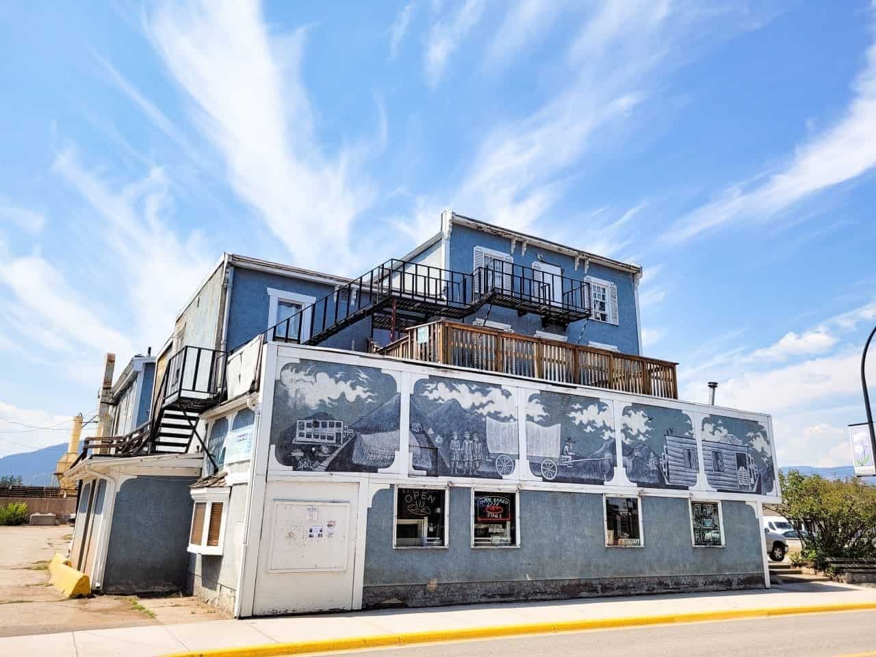 A historic downtown Armstrong building with a hand-painted mural, storefront windows, and an "Open" sign